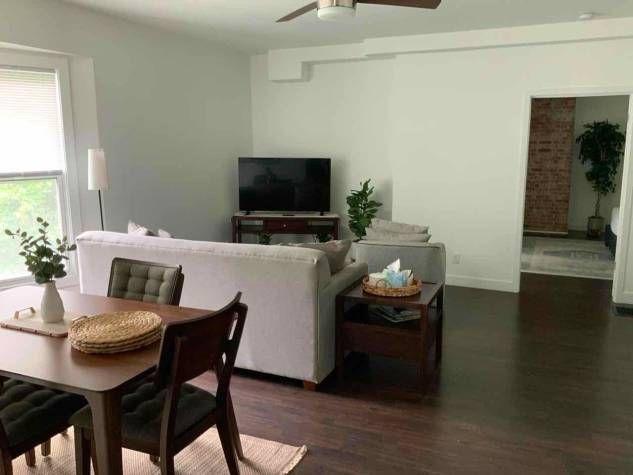 Furnished living and dining area of the short-term stay at 157 N Douglas, Springfield, IL, with a sofa, dining table, and hardwood floors